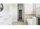 Bright hallway leading to the bathroom featuring a tub, walk-in closet and white doors at 6084 Sw 150Th Ln, Ocala, FL 34473