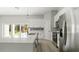 Modern kitchen with stainless steel appliances, white cabinetry, large island, and sliding glass doors at 6084 Sw 150Th Ln, Ocala, FL 34473