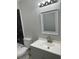 Modern bathroom with a gray vanity, white countertop, and stylish mirror at 635 Malaga Ave, Deltona, FL 32725