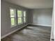 Bright living room featuring new gray vinyl plank flooring and many windows bringing in natural light at 635 Malaga Ave, Deltona, FL 32725