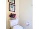 Toilet with flowers and framed art for a pleasant bathroom experience at 7407 Excitement Dr, Reunion, FL 34747