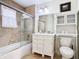 Well-lit bathroom with a tub, marble-patterned walls, and ample vanity storage at 7407 Excitement Dr, Reunion, FL 34747