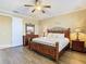 Bedroom with a dark wood sleigh bed, side tables, dressers, and wood floors at 7407 Excitement Dr, Reunion, FL 34747