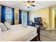 Bedroom with wood floors, a ceiling fan, and blue curtains on the doors to the balcony at 7407 Excitement Dr, Reunion, FL 34747