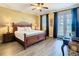 Bedroom with a dark wood sleigh bed, side tables, and french doors with curtains at 7407 Excitement Dr, Reunion, FL 34747