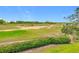 Scenic view of a golf course with lush greenery and distant buildings at 7407 Excitement Dr, Reunion, FL 34747