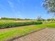 Picturesque golf course view with lush green grass, manicured hedges, and a view of the club house in the distance at 7407 Excitement Dr, Reunion, FL 34747