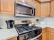 Close up view of kitchen with stainless steel appliances and light wood cabinets at 7407 Excitement Dr, Reunion, FL 34747