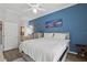 Bright bedroom features a blue accent wall, comfortable bed, and ensuite bathroom at 7620 Bay Port Rd # 39, Orlando, FL 32819