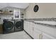 Modern laundry room with sleek washer and dryer, white cabinets, and stylish decor at 9888 Mere Pkwy, Orlando, FL 32832