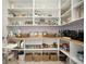 Well-organized walk-in pantry with custom shelving, patterned tile backsplash, and ample storage at 9888 Mere Pkwy, Orlando, FL 32832