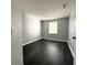 Simple bedroom featuring dark wood floors and ample natural light from the window at 1010 Loch Vail # 1125, Apopka, FL 32712