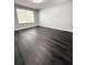 Neutral bedroom with dark wood flooring, gray walls, and a large window at 1010 Loch Vail # 1125, Apopka, FL 32712