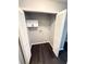 Bright laundry room features dark wood flooring, utility closet, and overhead cabinets at 1010 Loch Vail # 1125, Apopka, FL 32712