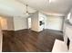 Open-concept living space showcasing dark wood floors, a white fireplace, and easy flow to the kitchen at 1010 Loch Vail # 1125, Apopka, FL 32712