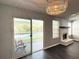 Bright living room with a fireplace, dark wood floors, a chandelier, and a sliding door leading to a balcony at 1010 Loch Vail # 1125, Apopka, FL 32712