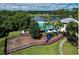 Aerial view of community playground, pool, and lake, surrounded by greenery at 10783 Satinwood Cir, Orlando, FL 32825