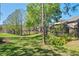 Expansive backyard featuring lush landscaping and a serene view of the nearby pond and screened patio at 10783 Satinwood Cir, Orlando, FL 32825