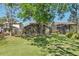 Large backyard featuring a screened patio, lush green lawn, and mature trees at 10783 Satinwood Cir, Orlando, FL 32825
