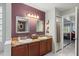 Bathroom featuring double sinks, dark wood cabinets, and a large mirror at 10783 Satinwood Cir, Orlando, FL 32825