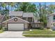 Charming two-story home featuring a well-maintained lawn, two-car garage, and inviting front entrance at 10783 Satinwood Cir, Orlando, FL 32825