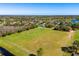 Aerial view showcasing the expansive green fields and the surrounding neighborhood with serene lakes nearby at 12712 Forestedge Cir, Orlando, FL 32828