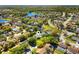 Aerial view of a residential neighborhood with winding roads, green spaces, and a tranquil lake at 12712 Forestedge Cir, Orlando, FL 32828