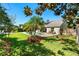 Spacious backyard featuring a swimming pool, lush lawn, tropical plants, and patio furniture at 12712 Forestedge Cir, Orlando, FL 32828