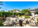 Beautifully landscaped backyard with patio seating, a grill, lush lawn, and mature trees at 12712 Forestedge Cir, Orlando, FL 32828