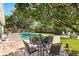 Backyard with a swimming pool, patio, dining set, and lush landscaping, creating a private oasis at 12712 Forestedge Cir, Orlando, FL 32828