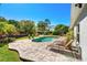 Backyard with a pool, patio, lounge chairs, and lush landscaping, offering a perfect outdoor retreat at 12712 Forestedge Cir, Orlando, FL 32828