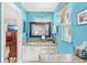Bright bathroom featuring blue walls, granite counters, and a vanity with a decorative framed mirror at 12712 Forestedge Cir, Orlando, FL 32828