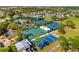 Aerial view of community amenities including pool, tennis courts, basketball court, and green spaces near a scenic lake at 12712 Forestedge Cir, Orlando, FL 32828