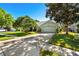 Exterior view of home with a two-car garage and well-manicured lawn at 12712 Forestedge Cir, Orlando, FL 32828