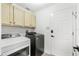 Laundry room featuring modern washer and dryer units and storage cabinets at 12712 Forestedge Cir, Orlando, FL 32828