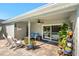 Covered patio area with seating overlooking the pool and landscaped backyard and sliding glass door at 12712 Forestedge Cir, Orlando, FL 32828