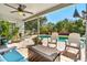 Covered patio area with comfortable seating overlooking the pool and landscaped backyard at 12712 Forestedge Cir, Orlando, FL 32828