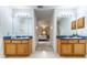 Bathroom with dual vanities and well-lit mirrors leading to a connected bedroom for convenience at 1272 Mount Logan Dr, Apopka, FL 32712