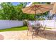 Inviting patio space with a glass table, umbrella, and well-maintained landscaping and privacy fence at 1272 Mount Logan Dr, Apopka, FL 32712
