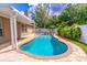 Backyard pool with waterfall feature, surrounded by brick pavers and lush tropical landscaping at 1272 Mount Logan Dr, Apopka, FL 32712
