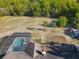 Aerial view of a property with a screened pool, a large backyard with palm trees, and wooded areas surrounding it at 133 Orange Ridge Dr, Longwood, FL 32779