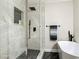 Walk-in shower and soaking tub in a renovated bathroom with marble tile and sleek black fixtures at 133 Orange Ridge Dr, Longwood, FL 32779