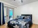 Bright bedroom with a plush floral comforter, throw pillows, and access to outdoor patio at 133 Orange Ridge Dr, Longwood, FL 32779