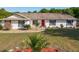 Beautiful home featuring a red door, stone accents, and meticulously maintained landscaping at 133 Orange Ridge Dr, Longwood, FL 32779