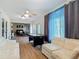 Bright living room featuring a sofa, air hockey table, large windows, and a view into the dining area at 133 Orange Ridge Dr, Longwood, FL 32779