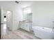 Bright bathroom featuring double vanities, a soaking tub, and wood-look floors at 16121 Sw 37Th Terrace Rd, Ocala, FL 34473