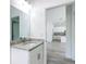 Bathroom with a granite vanity, mirror, and a glimpse into the open-concept kitchen at 16121 Sw 37Th Terrace Rd, Ocala, FL 34473