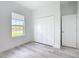 Bedroom featuring wood-look floors, bi-fold closet doors and a window with natural light at 16121 Sw 37Th Terrace Rd, Ocala, FL 34473