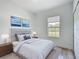 Stylishly staged bedroom featuring a queen bed, wood-look floors, and a window with outside views at 16121 Sw 37Th Terrace Rd, Ocala, FL 34473