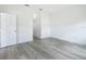 Empty bedroom with wood floors, white walls, and a door leading to the bathroom at 16121 Sw 37Th Terrace Rd, Ocala, FL 34473